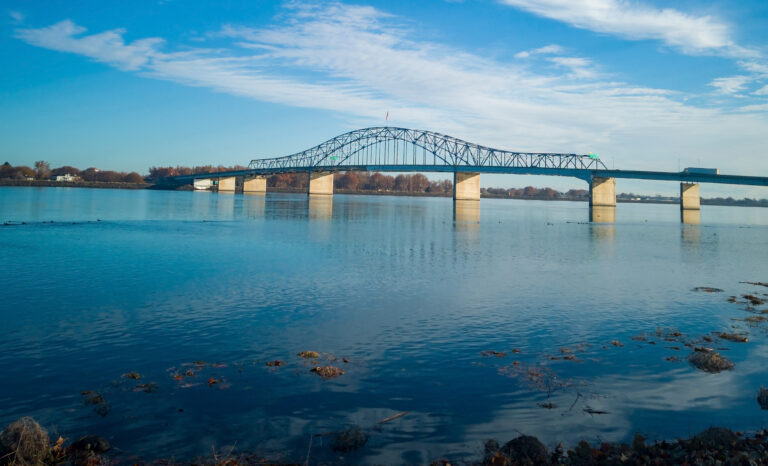 A Curved Bridge Extends Across Calm Waters